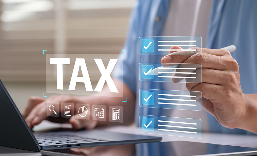 Close up of person using laptop with overlay illustration of tax checklists