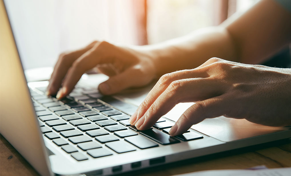 Close up of person typing on laptop keyboard