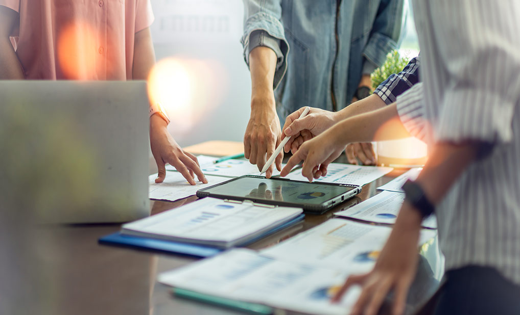 Close up of people's hands as they collaborate at a desk