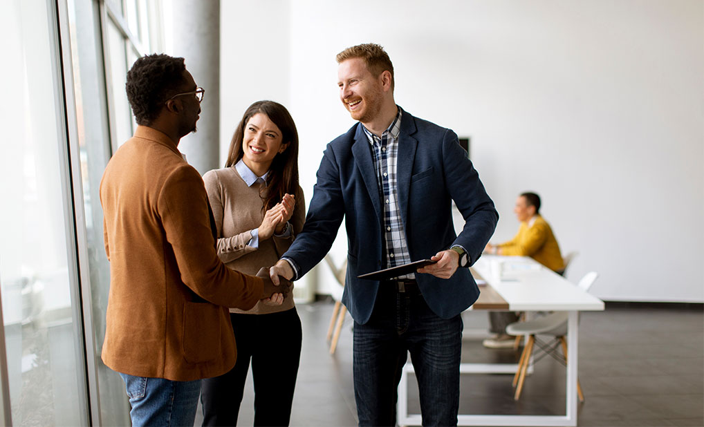 Group of business people talking and shaking hands in office