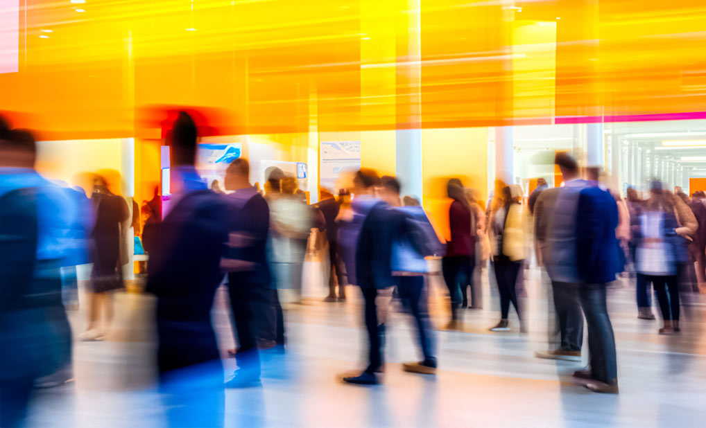 Abstract image of crowd of people walking in large hall