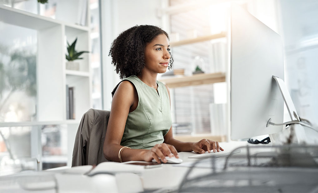 Businessperson sitting at desk and using computer