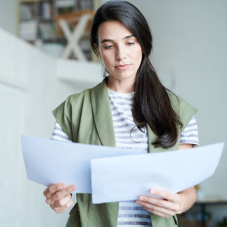 woman holding two sheets of paper