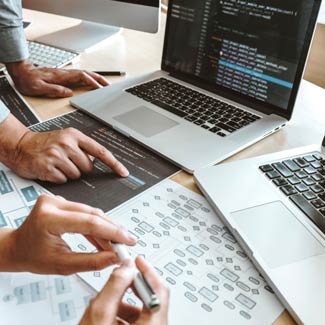 two people collaborating. one is pointing at a paper and the other has a marker ready