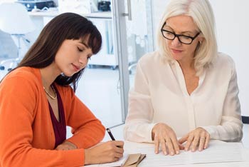 Two individuals examining notes
