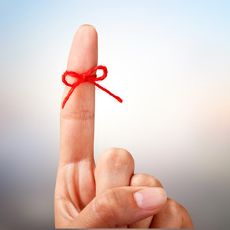 a red string tied around a finger as a reminder