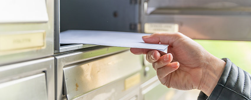 Hand taking a letter out of a mailbox