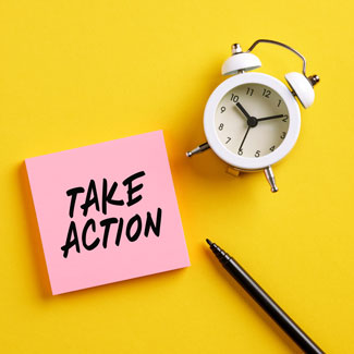 post-it note saying 'take action' next to an alarm clock