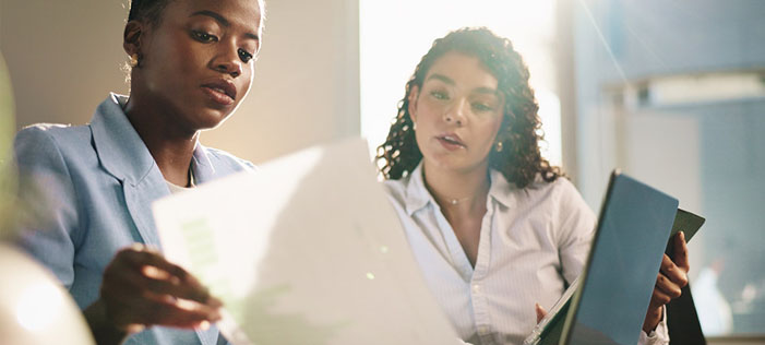 Two women looking at a report