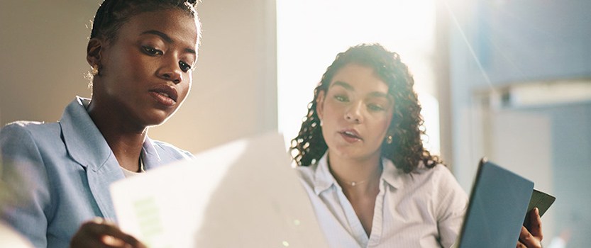 two businesswomen inspecting documents