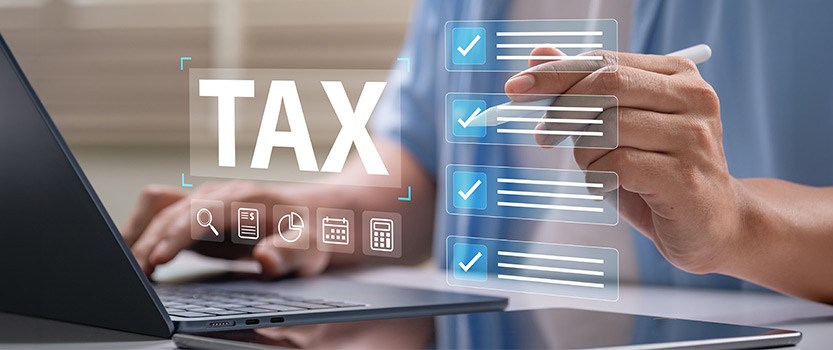 Individual checking virtual tax checklist that is hovering over open laptop