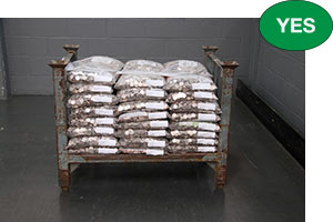 Correct stacking of plastic bags of coins on a pallet with the labels facing out.