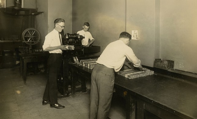 Group of men from the early 1900s packaging and organizing cash
