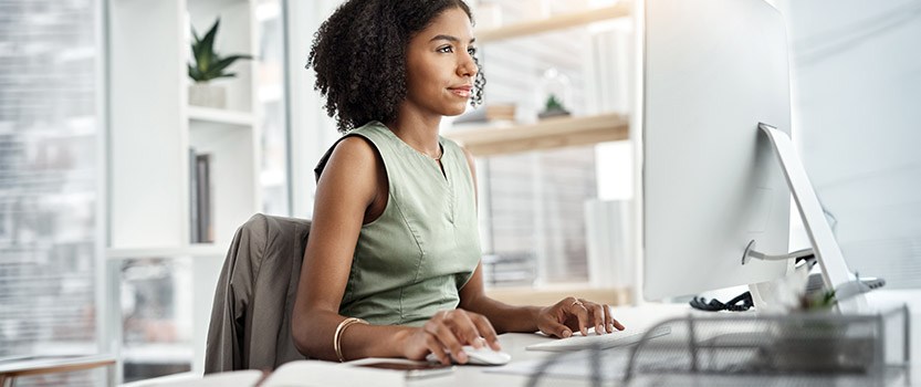 Businessperson sitting at desk and using computer