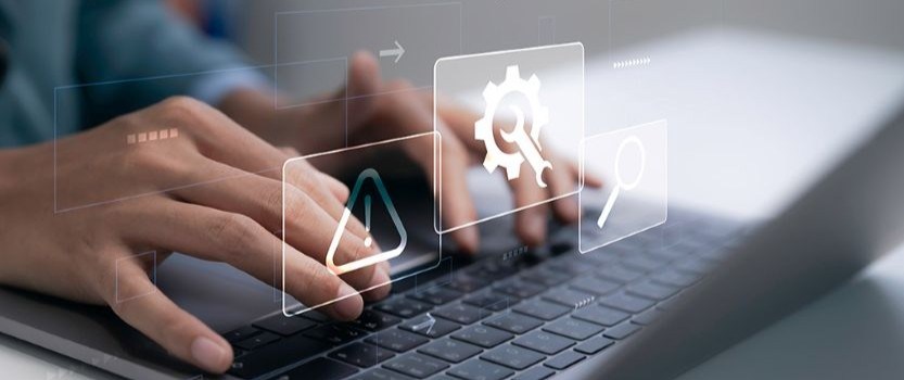 hands typing on laptop with floating settings icons
