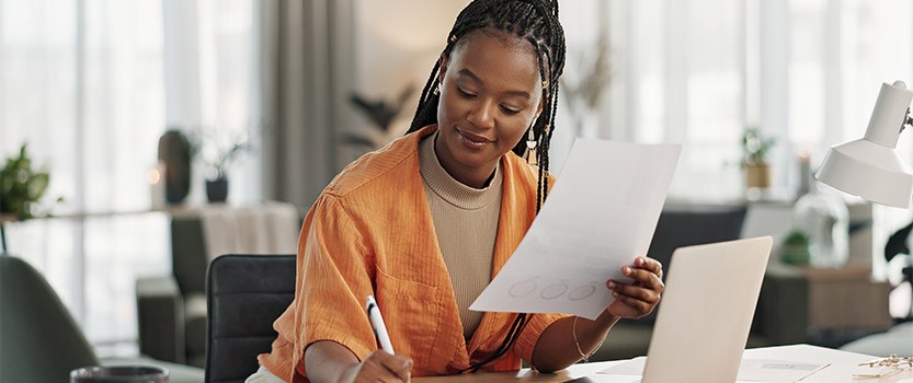 Businesswoman sitting at desk looking at papers