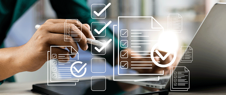 hand holding pen in front of laptop and virtual checklist