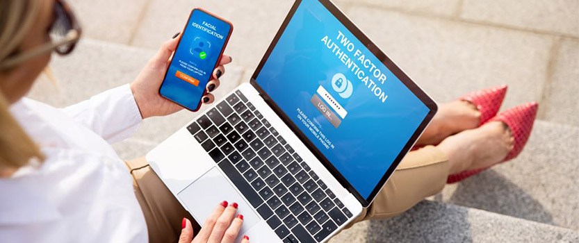 Person logging into computer using two-factor authentication on phone