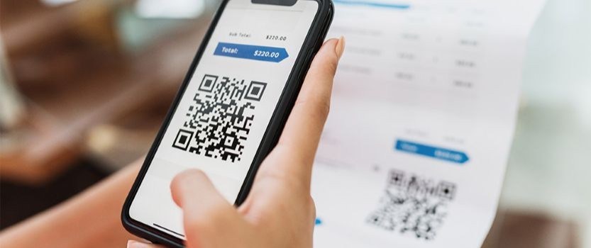 hand holding phone displaying QR code