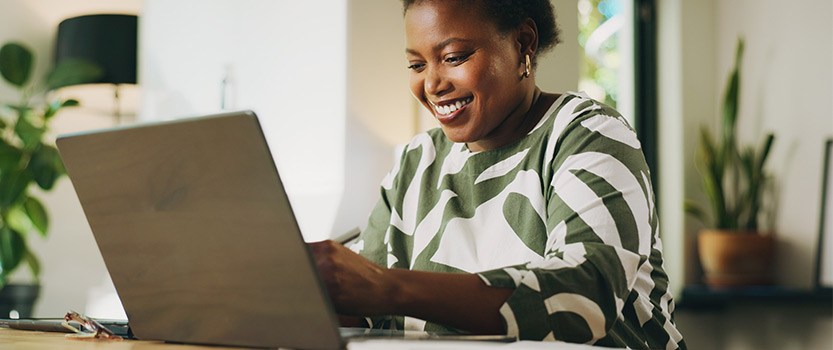 Businessperson looking at laptop and smiling